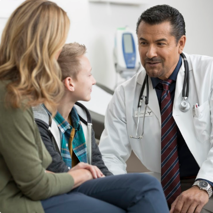 doctor speaking with boy and his mother